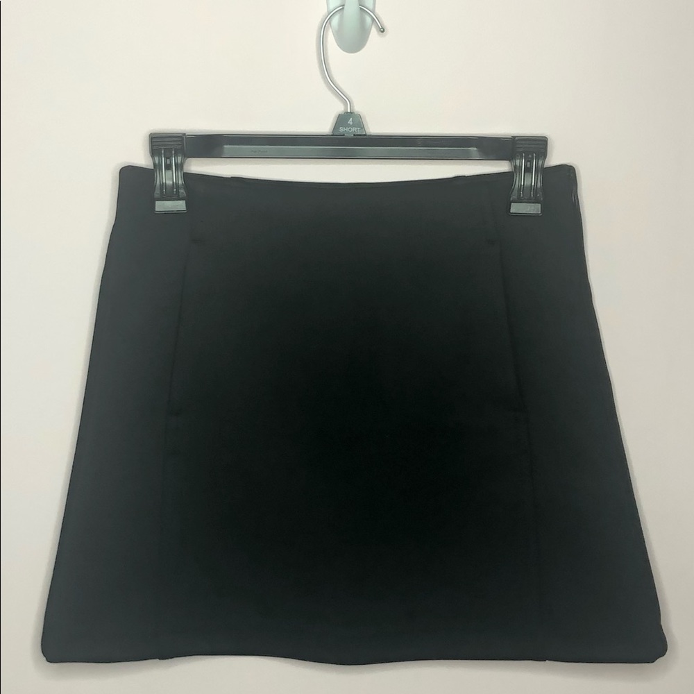High-waisted mini skirt. Front pockets. Seam zip.
